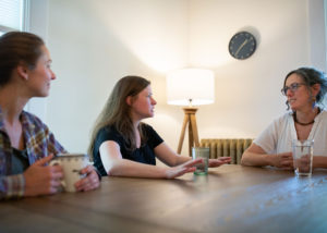 staff talking at table in voss house