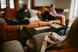 group of people sitting on a couch writing