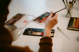 person painting with water colors