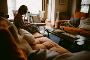 woman sitting on a couch with a blanket