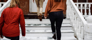 Women walking up stairs outside a house