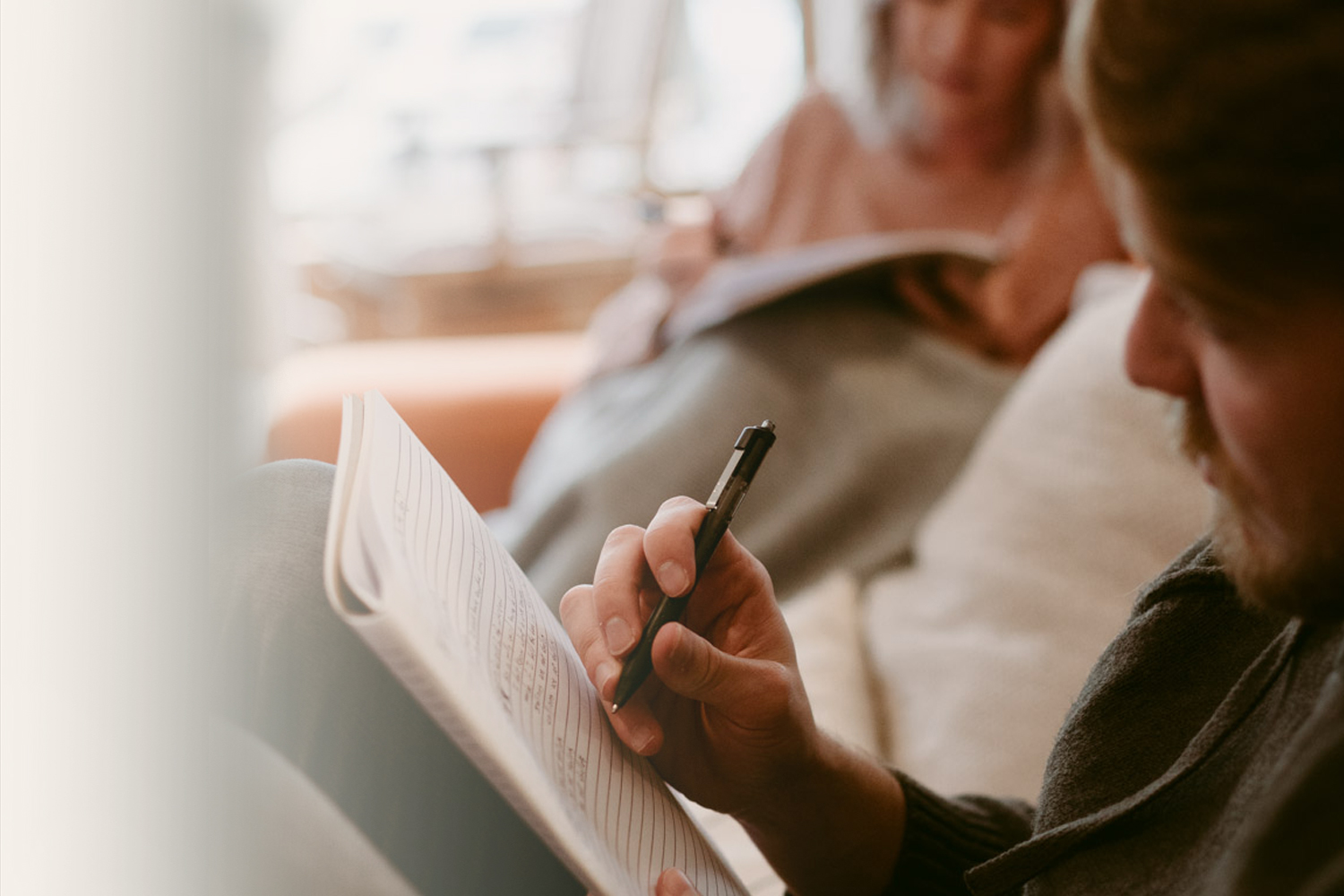 man writing in journal