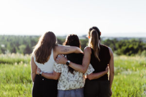 Girls hugging watching looking into the sun