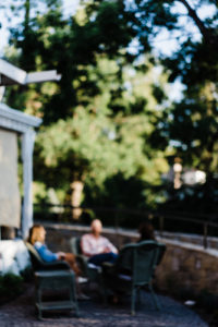 blurred picture of three people sitting on a patio